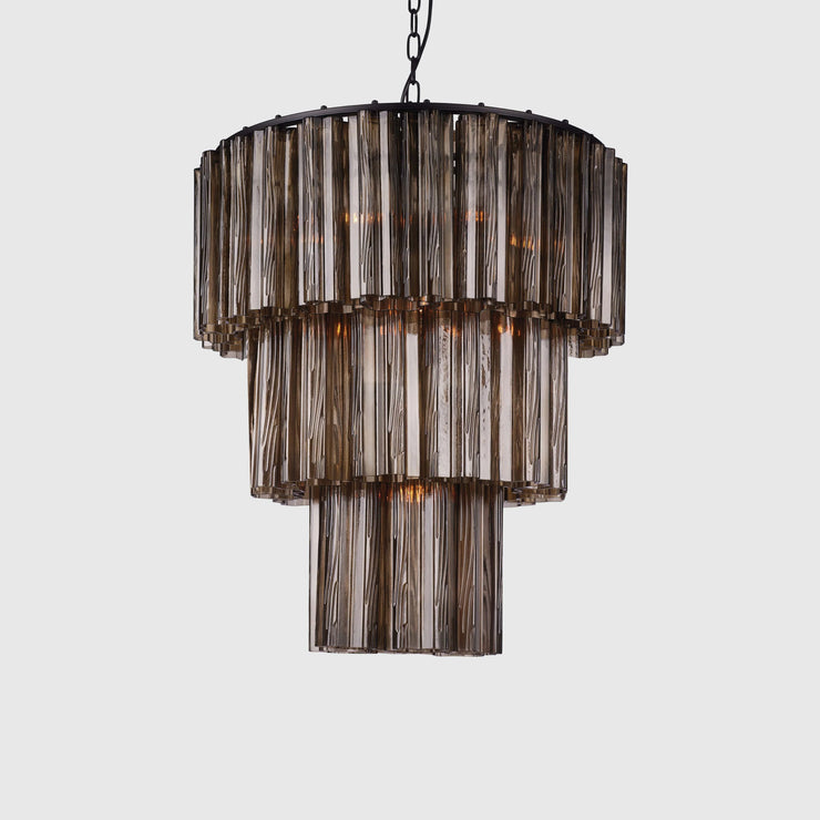 Lysekronen Fontaine Chandelier fra norske Meublé smykker ethvert rom den henger i! Vakkert formede glassylinderne i munnblåst brunt glass slipper lyset gjennom på en delikat måte og gir rommet en helt egen stemning når den er tent. Her i den mellomste størrelsen, med 3 lag. 