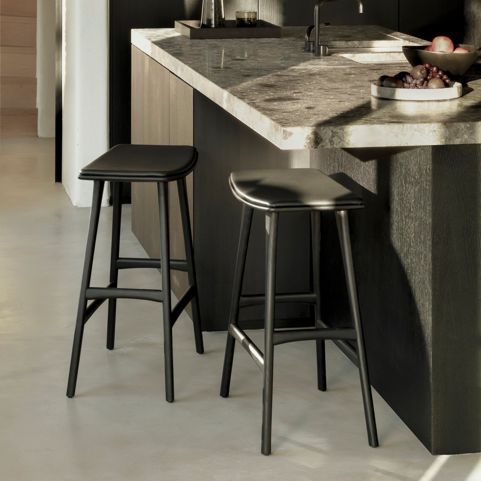 Barkrakk Osso Counter Stool (H67 cm) i sortlakkert eik/black oak med sittepute i svart skinn fra Ethnicraft.