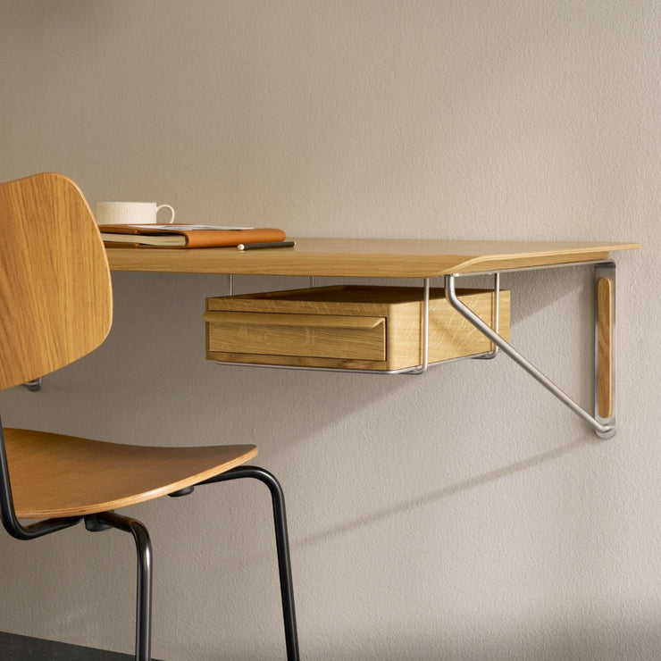Det vegghengte skrivebordet AB019 Wall desk fra Carl Hansen & Søn kan bestilles med en separat skuff i heltre eik – enten montert under for oppbevaring, eller plassert oppå som et praktisk laptopstativ.
