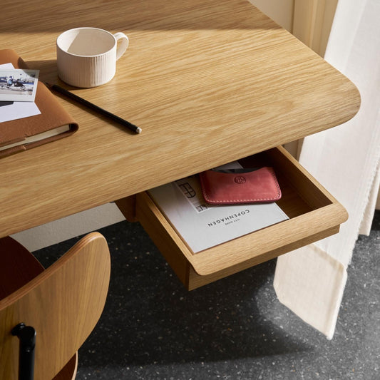 Det vegghengte skrivebordet AB019 Wall desk fra Carl Hansen & Søn kan bestilles med en separat skuff i heltre eik – enten montert under for oppbevaring, eller plassert oppå som et praktisk laptopstativ.