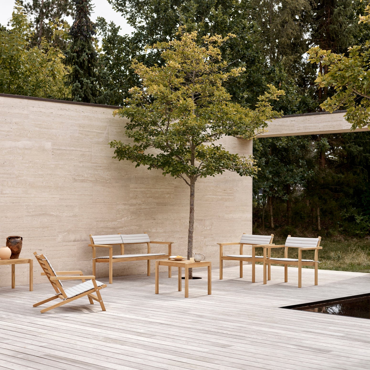 Utesofaen AH701 Outdoor Lounge Sofa og sidebordet AH911 Outdoor Side Table fra Carl Hansen & Søn.