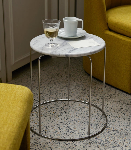 Løft interiøret med et fint sidebord! Wire Stool VP11 fra &tradition, designet av ikoniske Verner Panton i 1981, er en flerfunksjonell krakk i speilpolert rustfritt stål som kan kjøpes med og uten sittepute – og nå også med bordplate i hvit eller svart marmor!