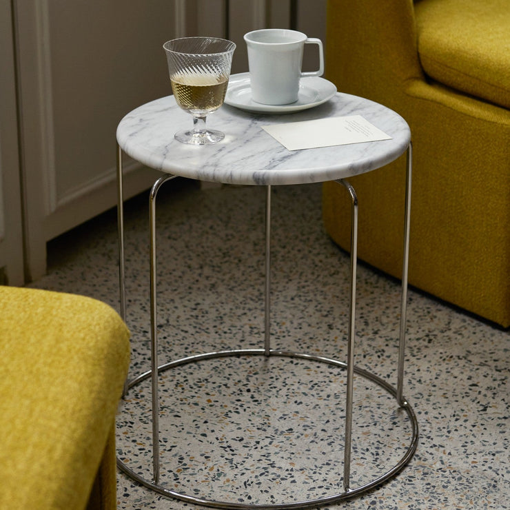 Løft interiøret med et fint sidebord! Wire Stool VP11 fra &tradition, designet av ikoniske Verner Panton i 1981, er en flerfunksjonell krakk i speilpolert rustfritt stål som kan kjøpes med og uten sittepute – og nå også med bordplate i hvit eller svart marmor!