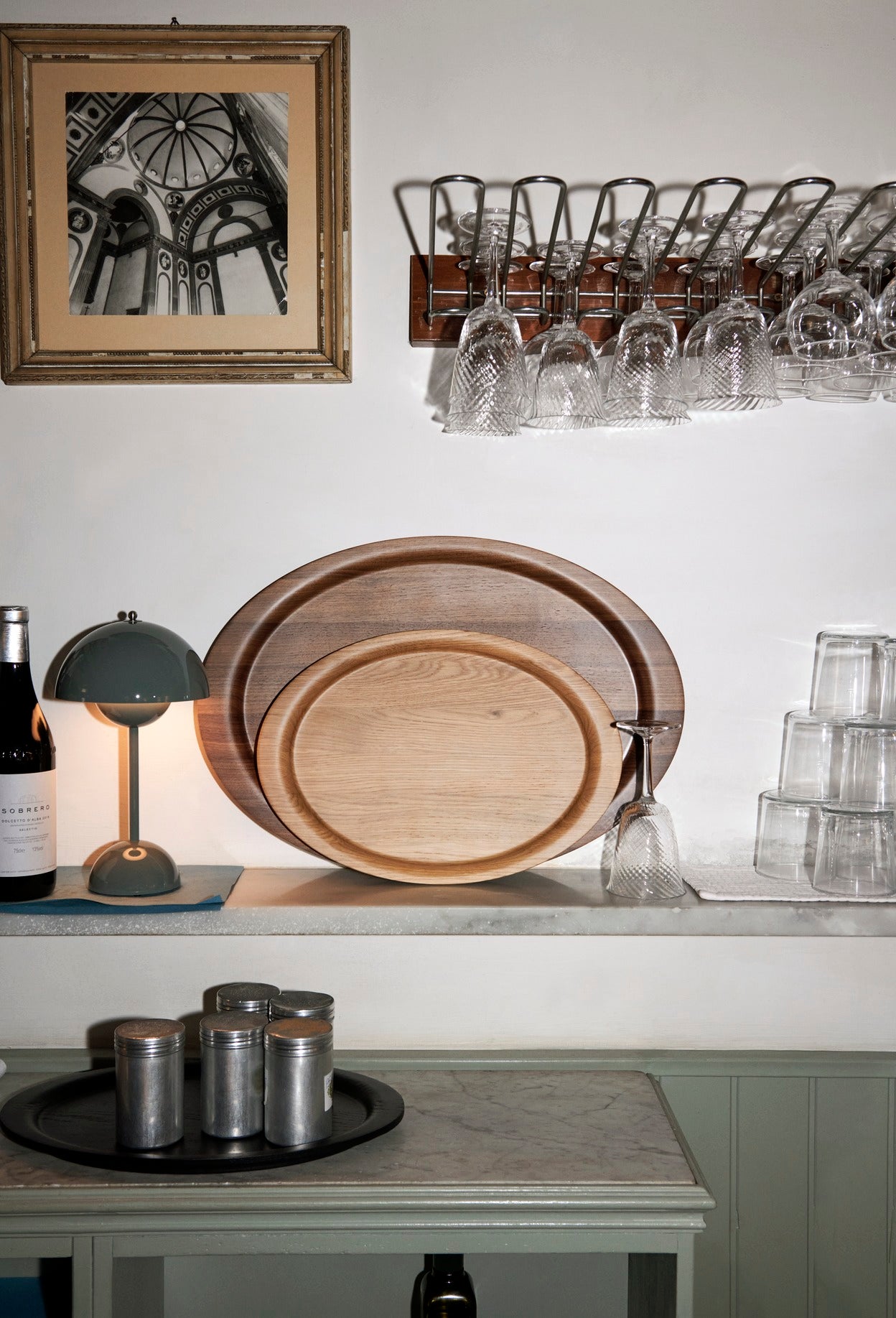 Bilde av kjøkkenkrok med de ovale serveringsbrettene Collect i heltre valnøtt og eik fra &tradition. Brettene har opphøyd kant.