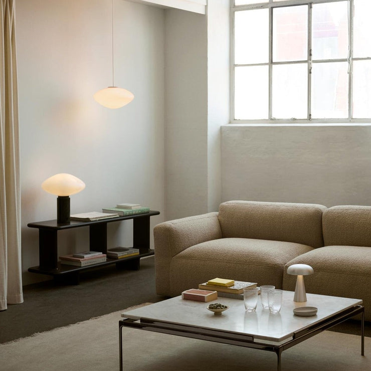 De mykt avrundede kantene og ulike breddene på hyllene gjør den spennende og litt leken i formen, mens materialene og dimensjonene tilfører den en elegant tyngde.