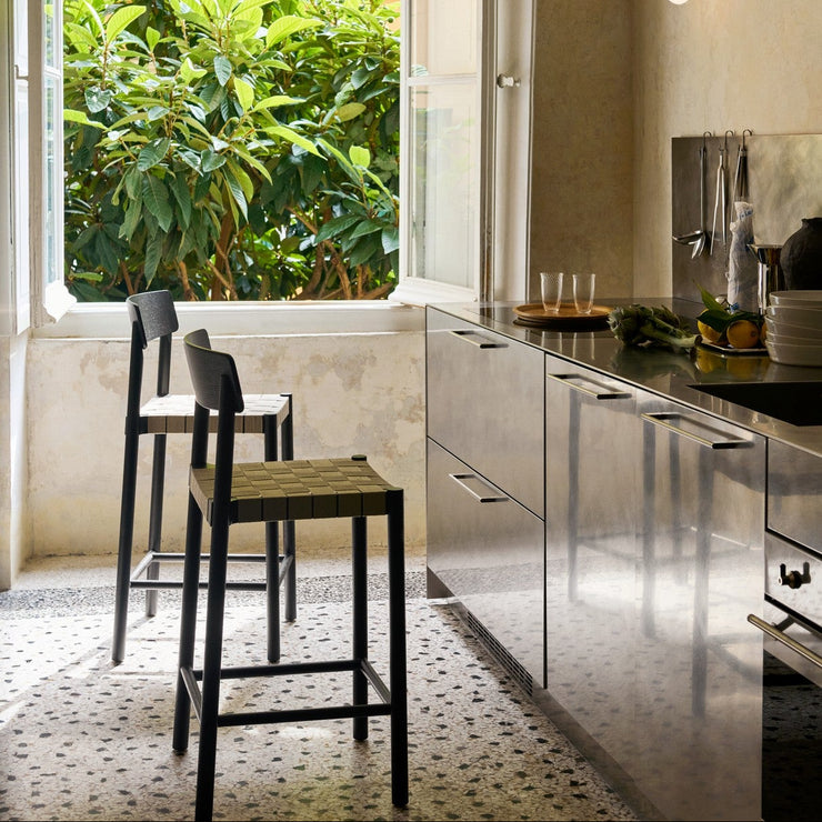 Designet er signert den finske designeren Sami Kallio og den danske designeren Jakob Thau og vi liker så godt det håndlagde preget. Barstolene har god sittekomfort og den solide trerammen er lett og luftig i uttrykket. Høyden gjør disse perfekt til de fleste norske kjøkken og kjøkkenøyer.