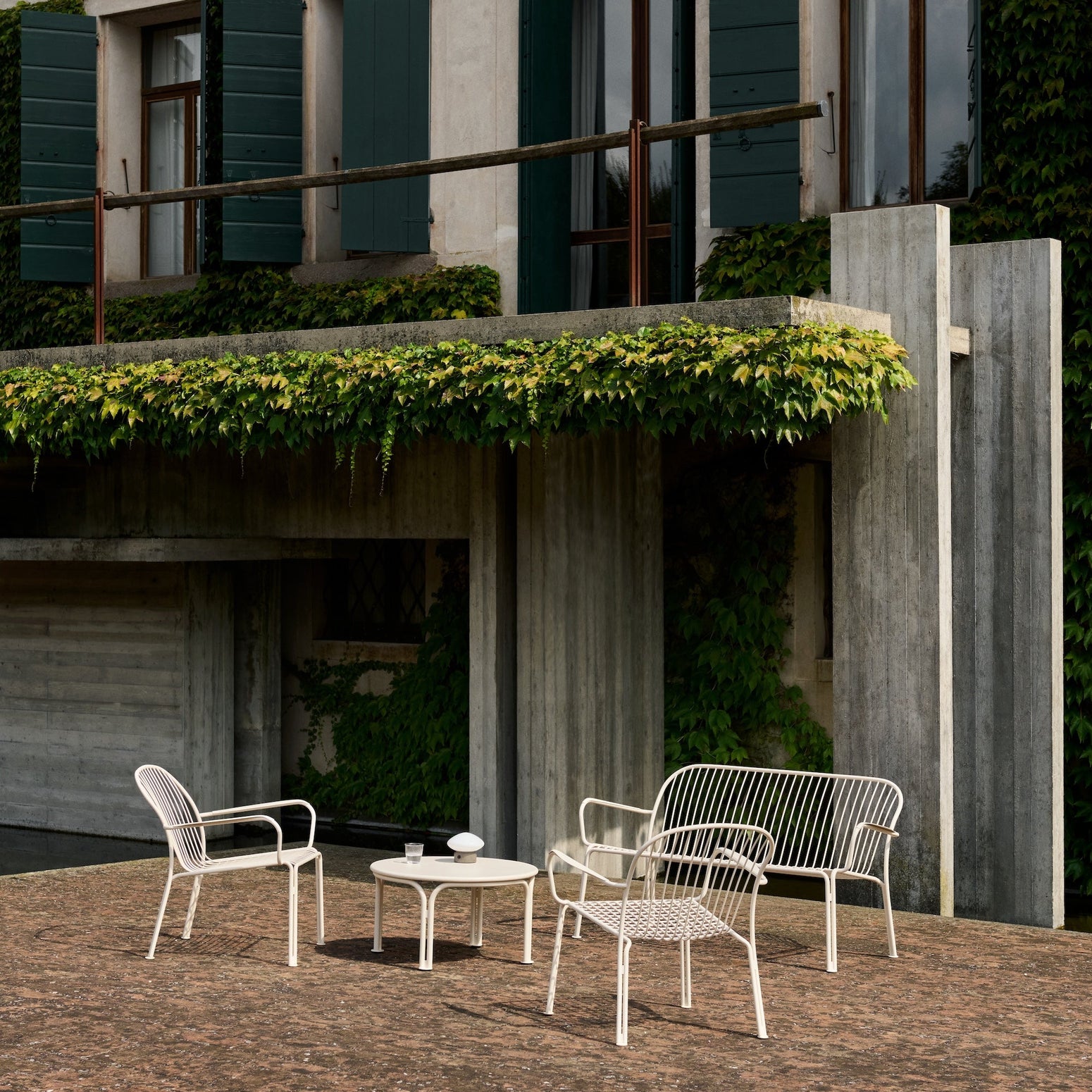 Hvit loungesofa til uteplassen, Thorvald SC110 fra &tradition, med loungebord og stoler i samme serie
