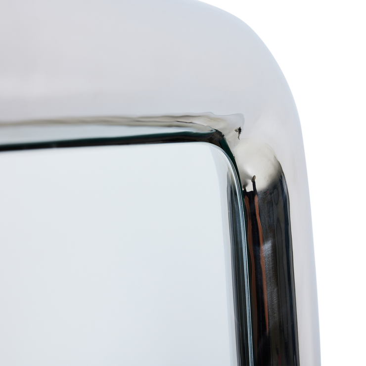 Speilet har en avrundet ramme i blankt, rustfritt stål.