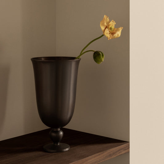 Vasen Pavot fra Audo Copenhagen henter inspirasjon fra en valmueblomst, og er støpt i aluminium med vakker mørk bronsefarget patina.