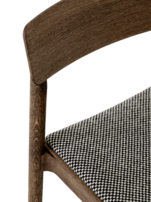 Trerammen er både solid og lett og det polstrede setet kan bestilles i et stort utvalg tekstiler og skinn. Her er setet trukket med tekstilet Sisu 165, et fantastisk fint smårutete ulltekstil fra Kvadrat.