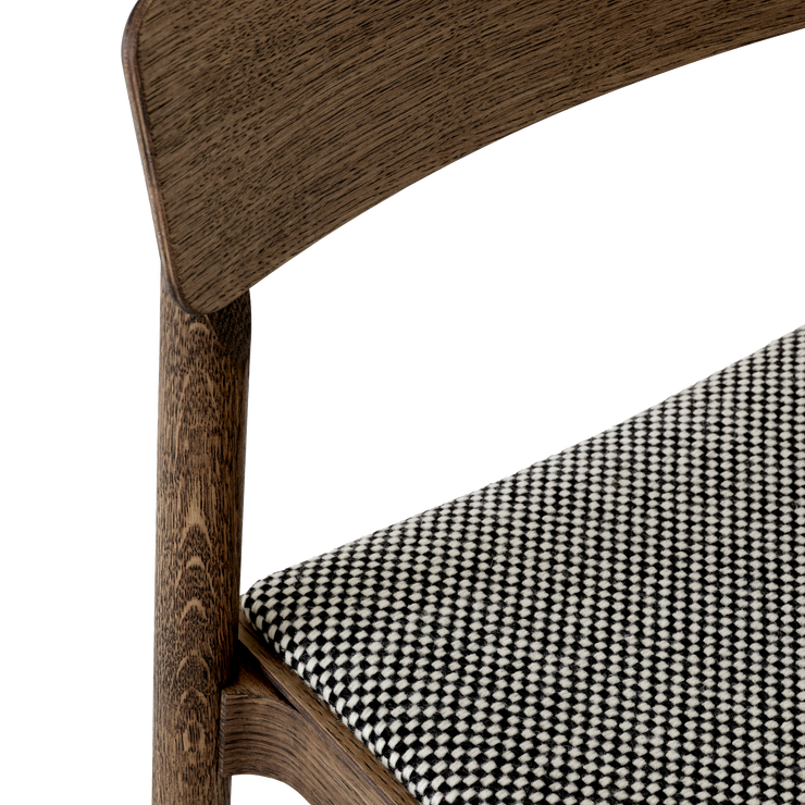 Trerammen er både solid og lett og det polstrede setet kan bestilles i et stort utvalg tekstiler og skinn. Her er setet trukket med tekstilet Sisu 165, et fantastisk fint smårutete ulltekstil fra Kvadrat.