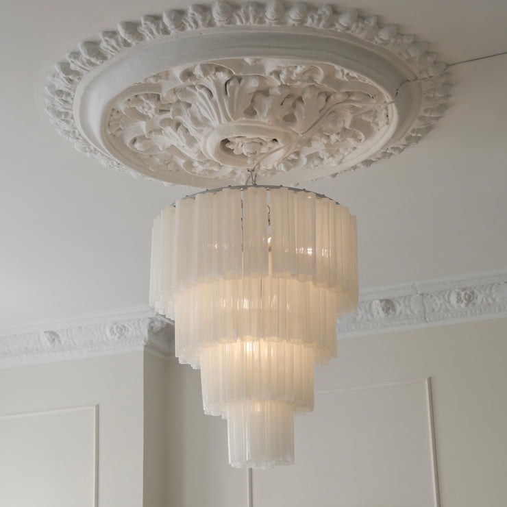 Her ser du lysekronen Fontaine Chandelier 4-layer fra Meublé i hvitt glass og krombelagt oppheng. Den stemningsfulle lysekronen er en del av en serie med lysekroner der du kan velge mellom tre ulike størrelser, der dette er den som bygger mest i høyden. Lysekronen måler Ø65 x H77 cm.