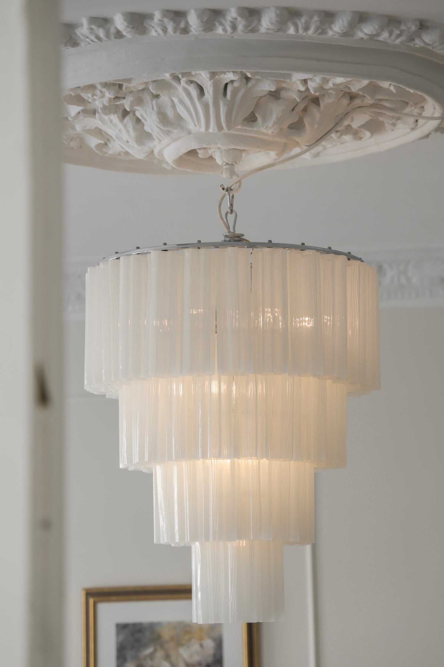 Lysekronen Fontaine 4-layer fra Meublé med hvitt glass og krombelagt oppheng