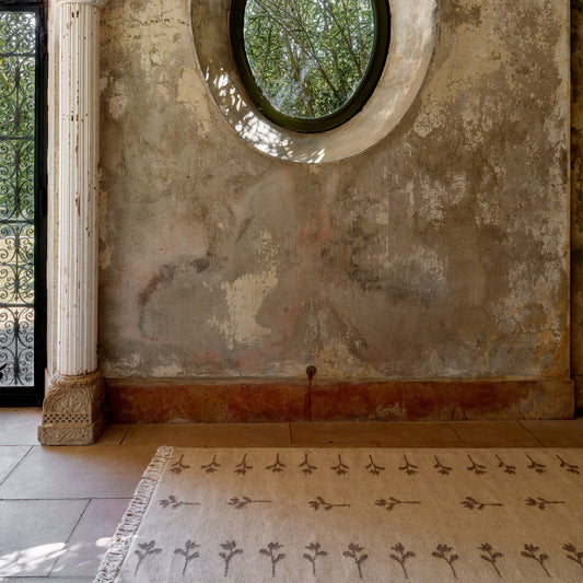 Teppet no.17 fra Cappelen Dimyr er et stort lett, flatvevd teppe i naturlig ull og bomull i en mellombeige farge med brune håndvevde blomster som er inspirert av gamle skandinaviske tulipanmønstre. Det er så vakkert!