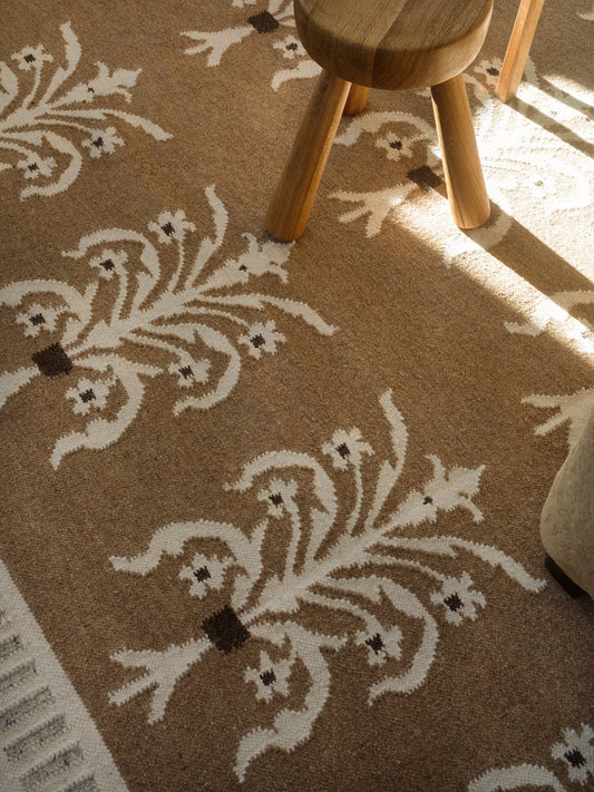 De blomsterinspirerte motivene er inspirert av dekorative veggdesign som finnes ved inngangene til flere av de tradisjonelle bygningene i Københavns historiske Frederiksberg-distrikt. Et rolig og sofistikert teppe med historisk sus. Så fint!