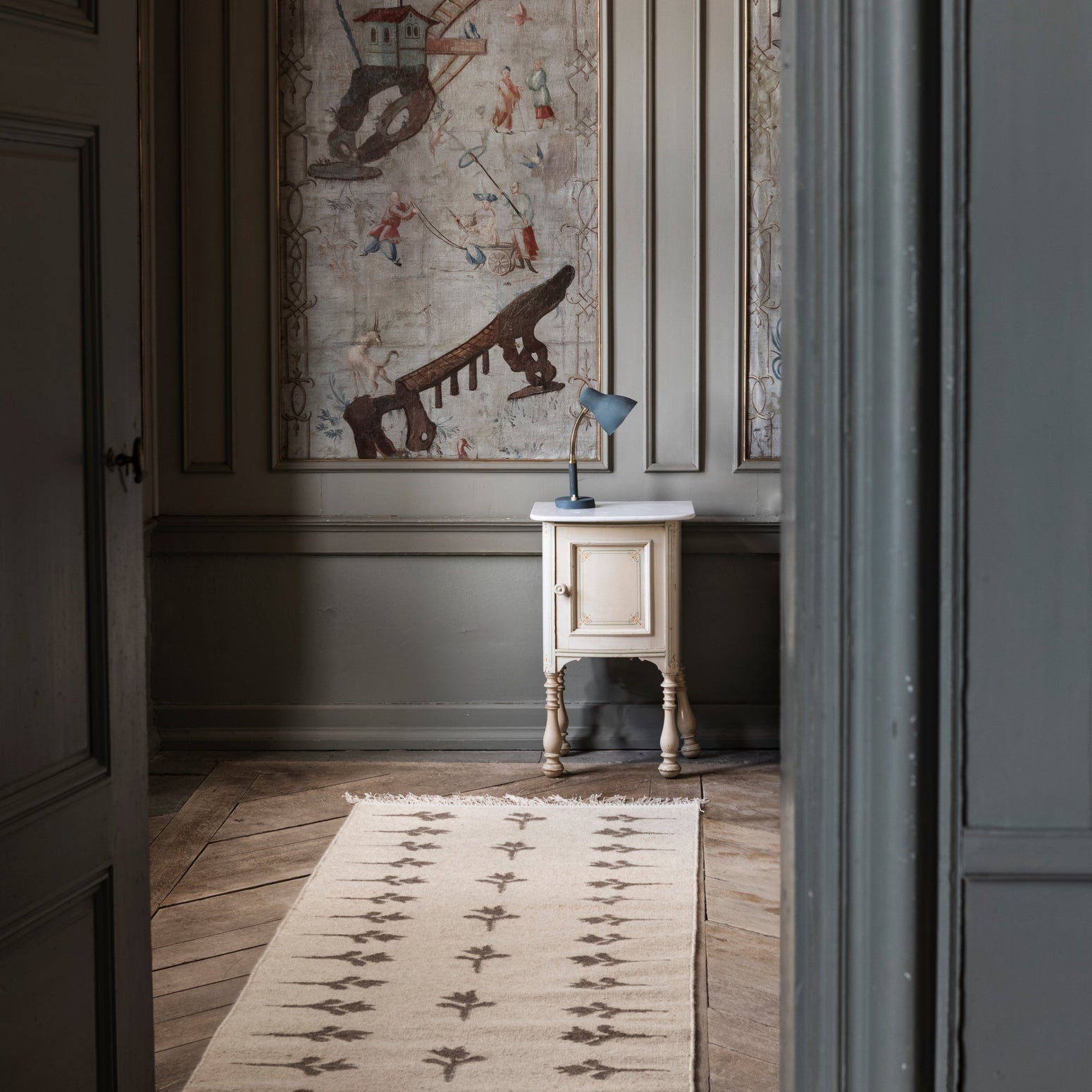 Løperen Colonnade no.08 fra Cappelen Dimyr er en lang, lett og flatvevd løper i naturlig ull og bomull i en mellombeige farge med brune håndvevde blomster som er inspirert av gamle skandinaviske tulipanmønstre. Smale frynser dekorerer kantene og gir løperen det lille ekstra.