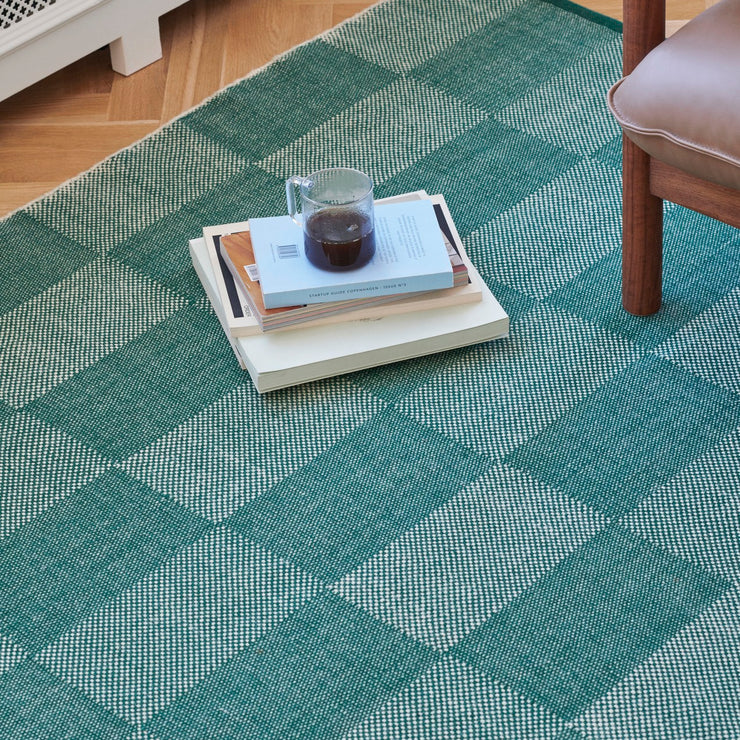 Det grønne teppet i serien Check Rug fra Hay er superfint til treverk, skinn og lyse flater.