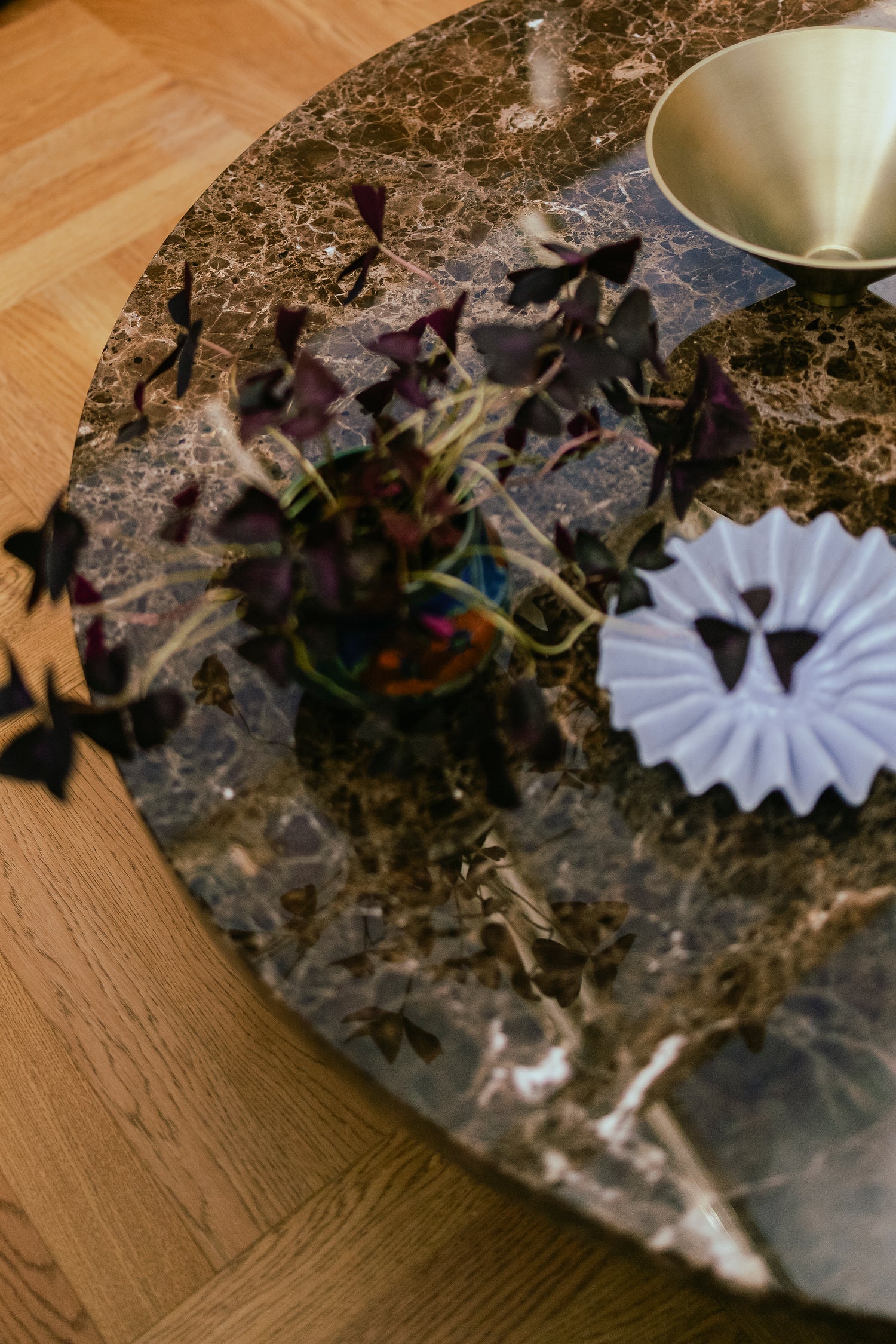 Rundt sofabord i brun blankpolert Emperador-marmor fra OsloDeco med detaljer i messing og lys blått. Foto: OsloDeco