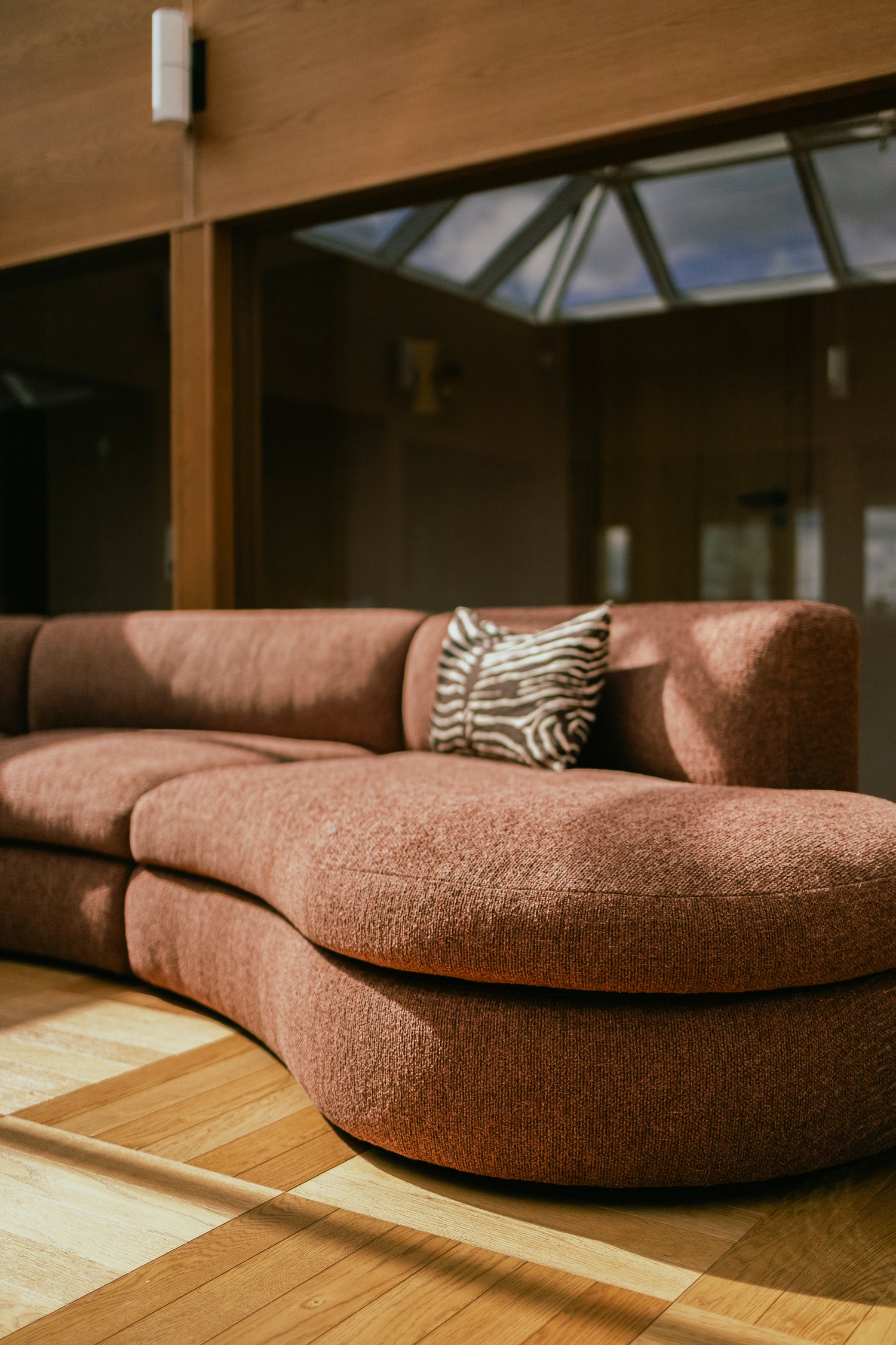 Buet sofa Coda fra New Works i rustfarget bouclétekstil fra OsloDeco i atriumstue renovert av AlexArk. Foto: OsloDeco