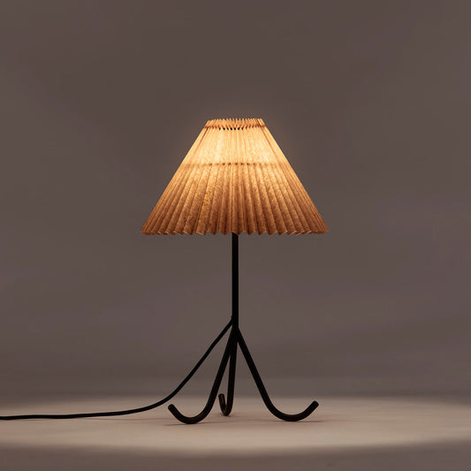 Den elegante bordlampen Geraldine fra Dusty Deco skaper en varm og innbydende atmosfære med sin vakkert plisserte skjerm i en sennepsgul nyanse. Lampeskjermen er laget i vokset papir, noe som gir skjermen en ekstra fin tekstur.