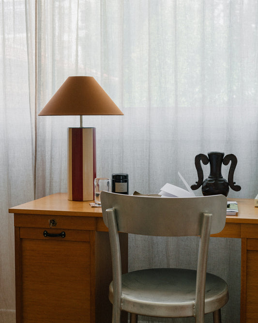 Bordlampen Ombrellina Oxblood & Cognac, i høyblank glasert okseblodrød- og smørkremgulglasert stripete keramikk med blå topp, tilhører Renaissance-kolleksjonen, som er inspirert av fargene brukt av malemestere under renessansen samt interiøret fra denne tidsepoken, da mørkt treverk og dype, varme farger regjerte. Formen er likevel moderne – og vi elsker uttrykket!