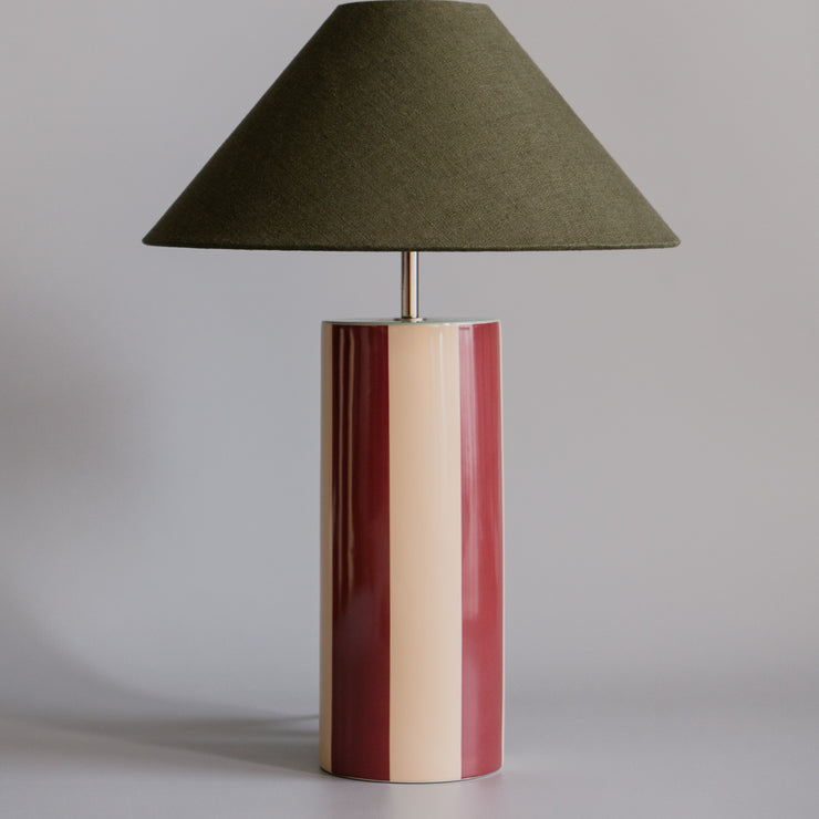 Bordlampen Ombrellina Oxblood & Seaweed, i høyblank glasert okseblodrød- og smørkremgulglasert stripete keramikk med mintfarget topp, tilhører Renaissance-kolleksjonen, som er inspirert av fargene brukt av malemestere under renessansen samt interiøret fra denne tidsepoken, da mørkt treverk og dype, varme farger regjerte. Formen er likevel moderne – og vi elsker uttrykket!