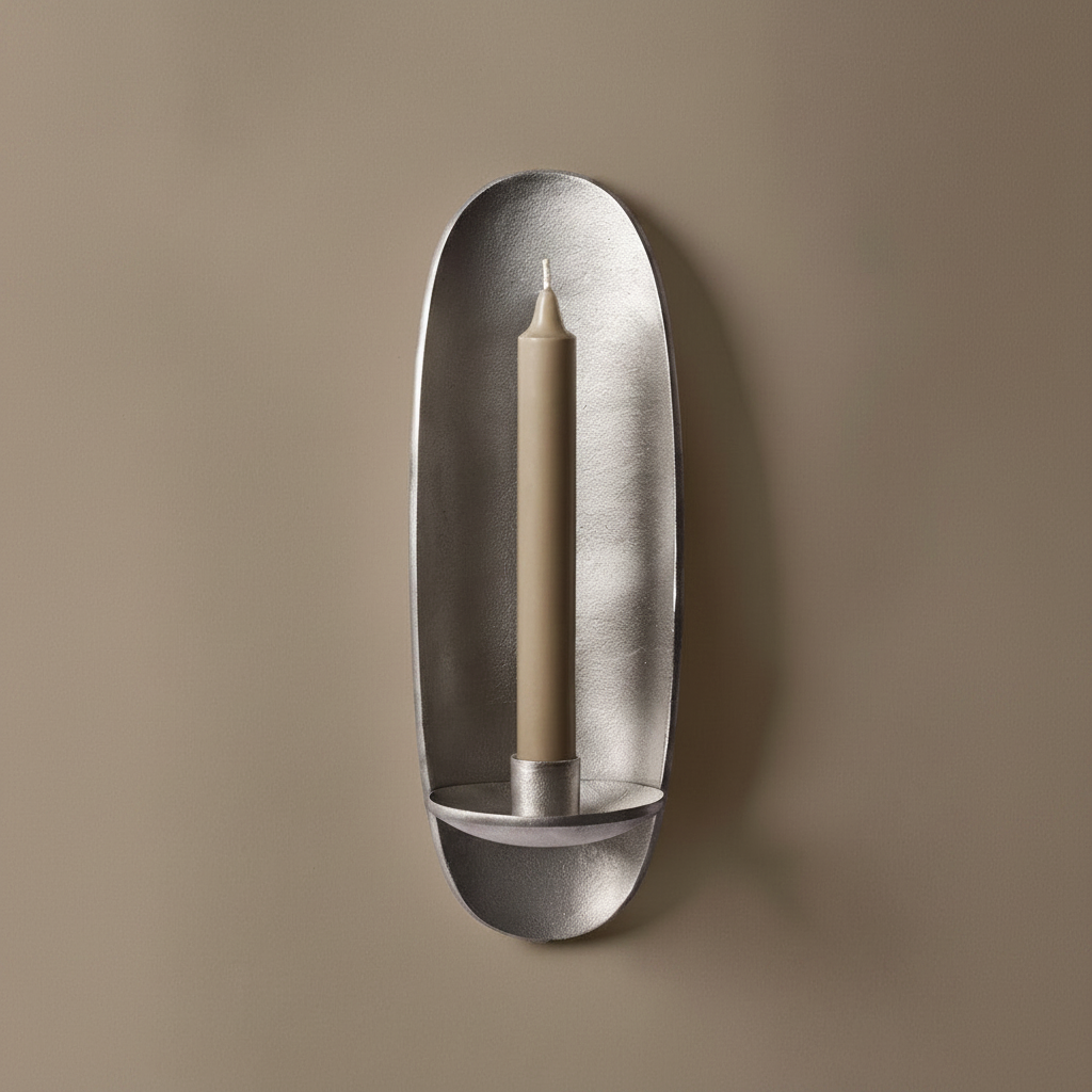 Den støpte vegglysestaken Agapé fra Ferm Living i aluminiumfinish gir deg et stemningsfullt blikkfang på veggen. Nydelig alene, men to stykker på hver sin side av et speil eller bilde, over en skjenk, er også superfint!