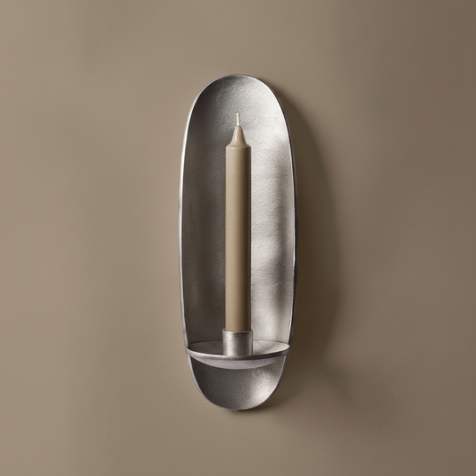 Den støpte vegglysestaken Agapé fra Ferm Living i aluminiumfinish gir deg et stemningsfullt blikkfang på veggen. Nydelig alene, men to stykker på hver sin side av et speil eller bilde, over en skjenk, er også superfint!