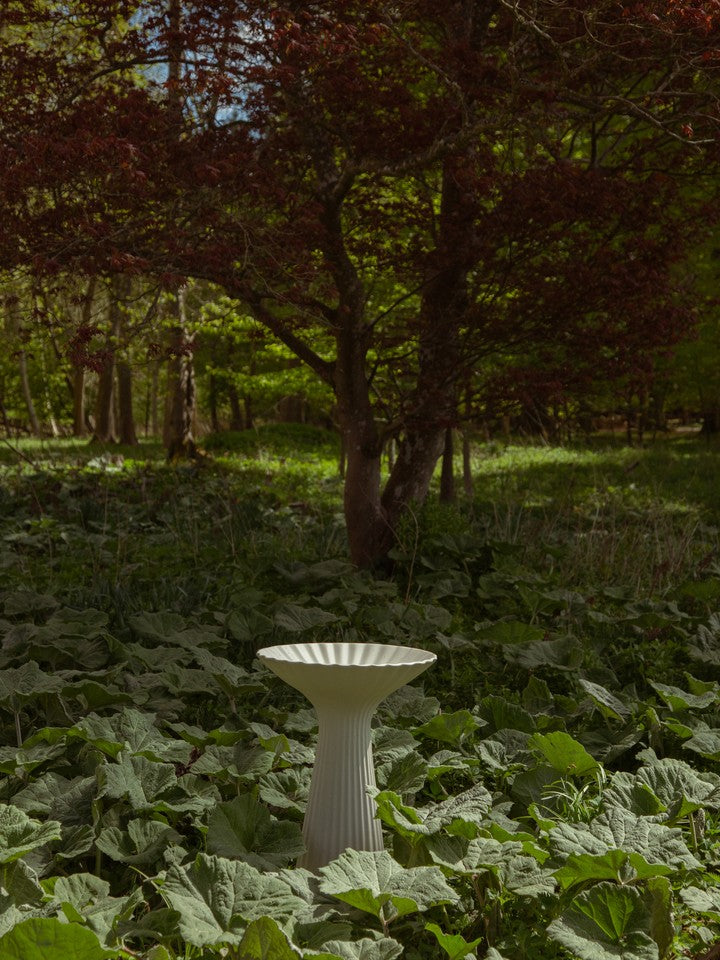 Fuglebad Fountain Pedestal Bowl fra ferm LIVING plassert utendørs i frodig hage