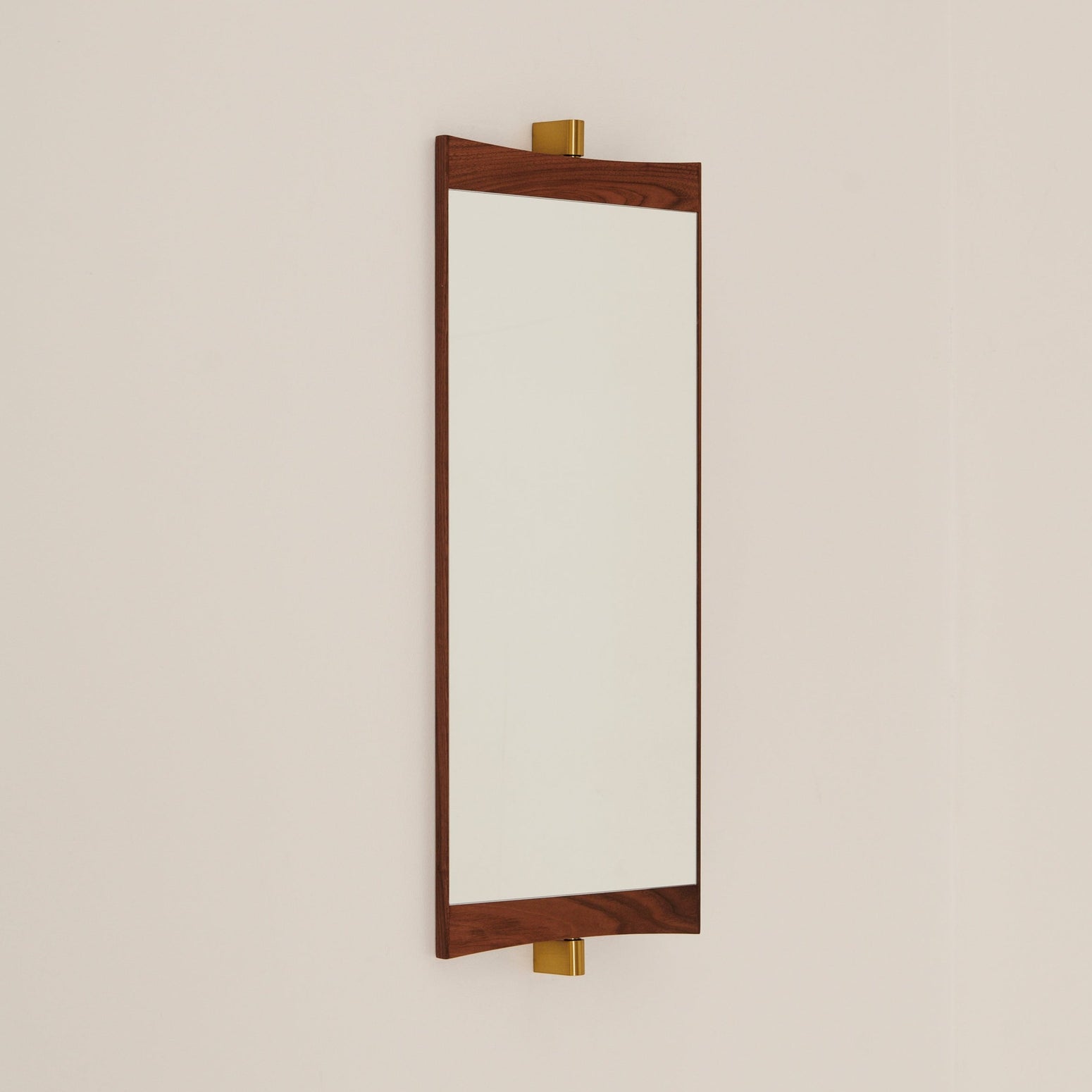 Speilene Vanity Mirror fra Gubi har ramme i varm valnøtt og detaljer i messing.