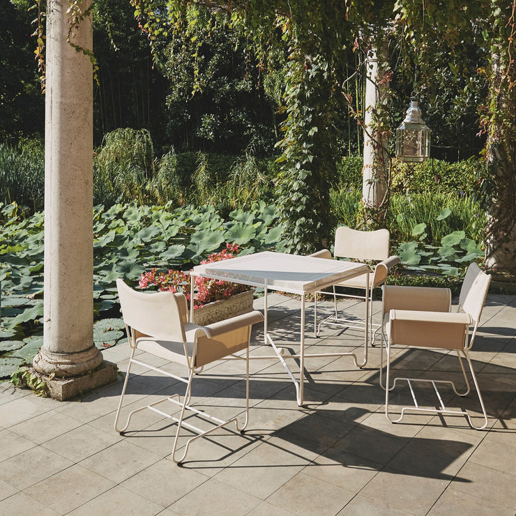 Det polstrede setet og ryggstøtten på Tropique Dining Chair er trukket i et jacquardstoff — egnet for utendørs bruk og som tåler UV-stråler – utviklet eksklusivt for Gubi. 