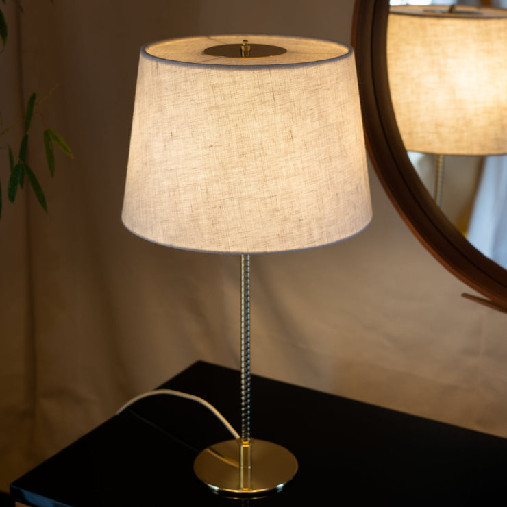 Når tent avgir bordlampen 9205 med kanvasskjerm fra Gubi et mykt og behagelig lys.