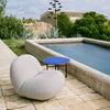 Lenestolen Pacha Outdoor Lounge Chair fra Gubi har runde, store former, gode proporsjoner, og er løftet lett fra bakken over en massiv base.