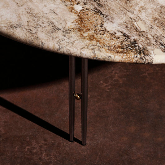 Sofabord IOI Ø100 cm fra Gubi: En rund bordplate i travertin – en nydelig varm kalkstein – hviler på et understell av en samling doble metallrør dekorert med en kule av messing imellom. Her med ben i krom.