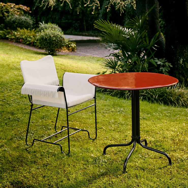 Vi ser for oss kafébordet Carmel Bistro Lounge Table fra Gubi i en lun hagekrok eller på balkongen, omringet av frodige blomster og planter!