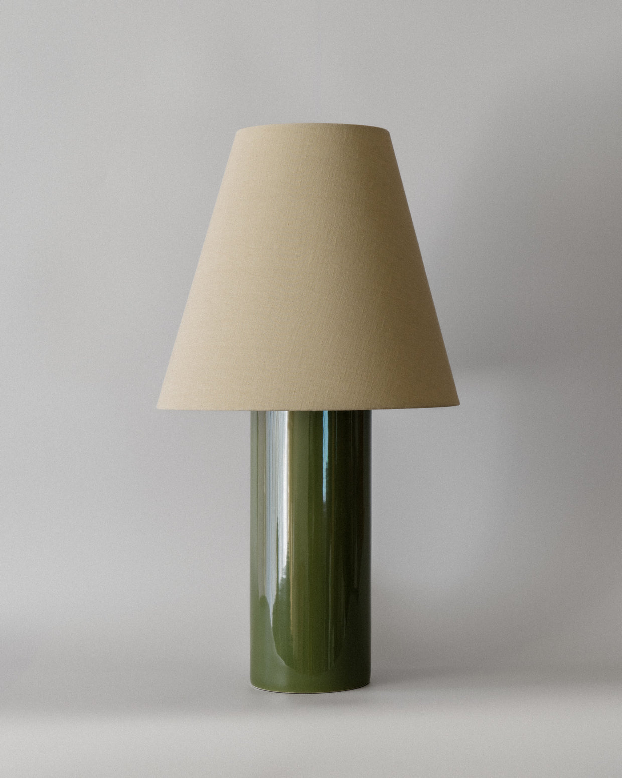 Bordlampen Giro Treetop & Beige har en keramisk sylinderformet lampefot med en skogsgrønn glasur og en konisk skjerm drapert i en teksturert lys beige bomull (fra Haider Ackermann) som sprer et behagelig og stemningsfullt varmt lys. En raffinert bordlampe som vil tilføre ethvert rom en dose sofistikert eleganse!