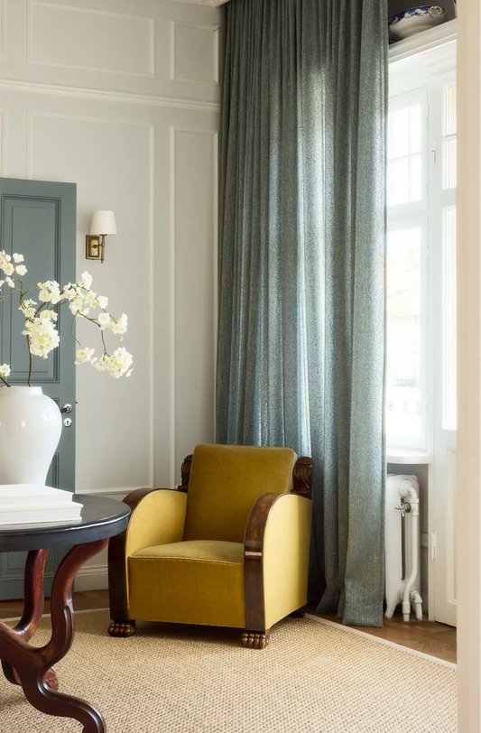 Bouclétekstilet er vevd av et ujevnt garn av 100% resirkulert polyester og er produsert med en spesiell teknikk der garnet formes til løkker eller knuter. Dette gir stoffet en nydelig karakteristisk overflate som kjennes deilig og eksklusiv og som gir gardinene en myk drapering med pene folder. 