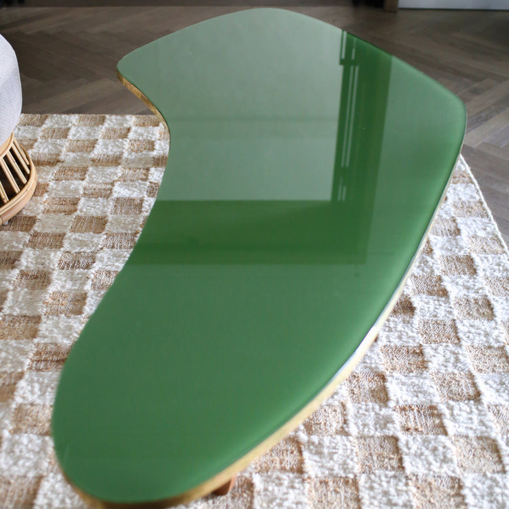 Dette vintage sofabordet i grønt glass, tre og messing er fra 1970-tallet og har fått navnet Boomerang etter formen, som flere andre lignende bord fra denne tidsperioden. Vi liker så godt de myke linjene og den vakre materialmiksen og vet at dette garantert vil tilføre innredningen din noe helt spesielt.