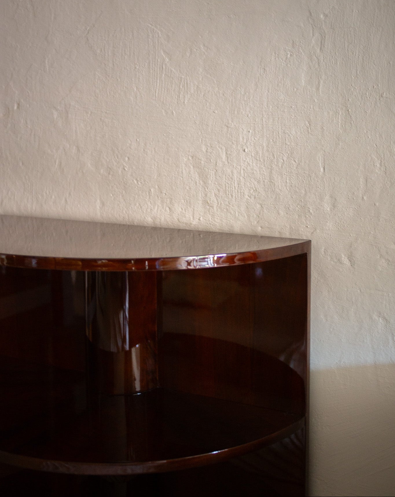 Vintage fransk halvsirkelformet bokhylle utført i blankpolert mørkbeiset valnøttfiner og sokkel i messing