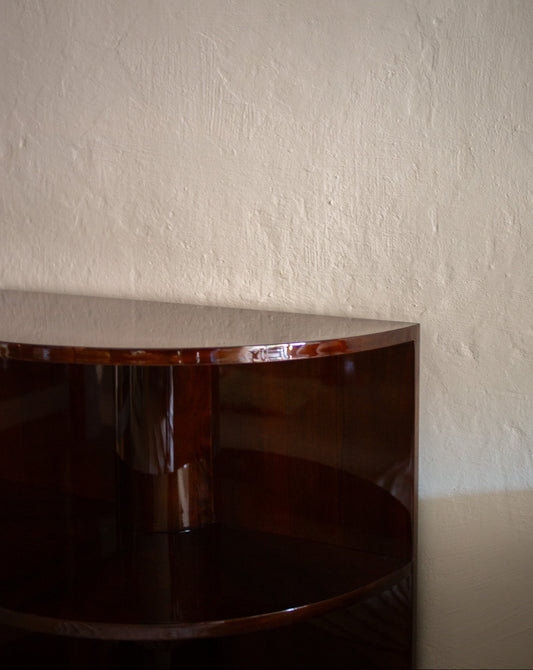 Vintage fransk halvsirkelformet bokhylle utført i blankpolert mørkbeiset valnøttfiner og sokkel i messing