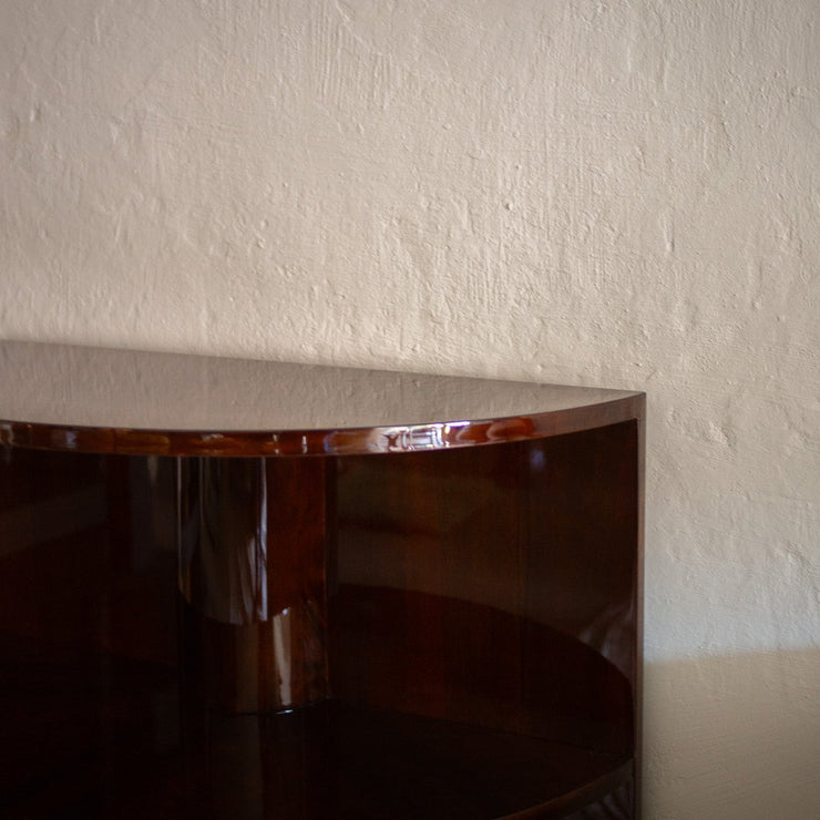 Vintage fransk halvsirkelformet bokhylle utført i blankpolert mørkbeiset valnøttfiner og sokkel i messing