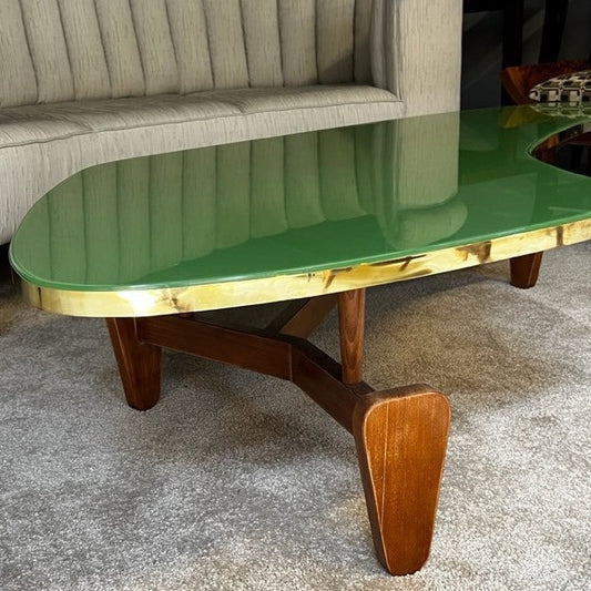 Dette vintage sofabordet i grønt glass, tre og messing er fra 1970-tallet og har fått navnet Boomerang etter formen, som flere andre lignende bord fra denne tidsperioden. Vi liker så godt de myke linjene og den vakre materialmiksen og vet at dette garantert vil tilføre innredningen din noe helt spesielt.
