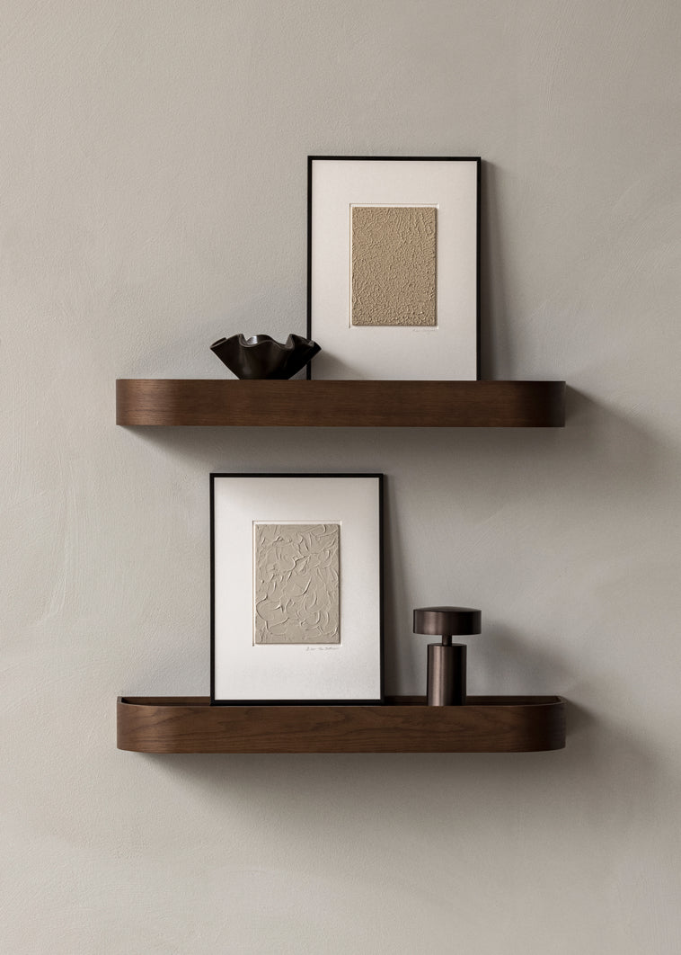 Bilde av tre små hyller i mørkebrunt tre som er hengt over hverandre på en gråbeige vegg. Disse heter Epoch og er fra Menu. 