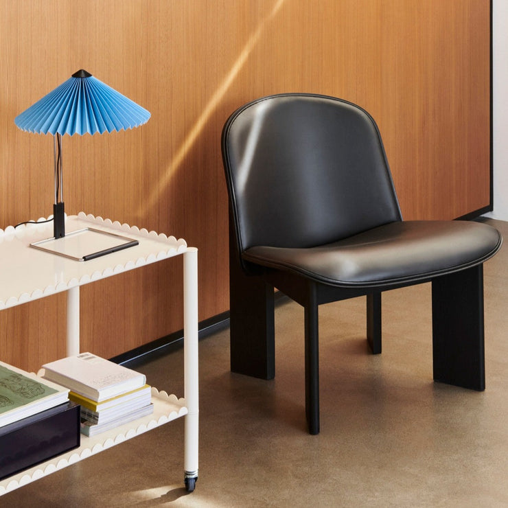 En klassisk kombinasjon er aldri feil. Her er lenestolen Chisel Lounge Chair fra Hay med base i svartlakkert bøk og polstret sete i svart skinn.