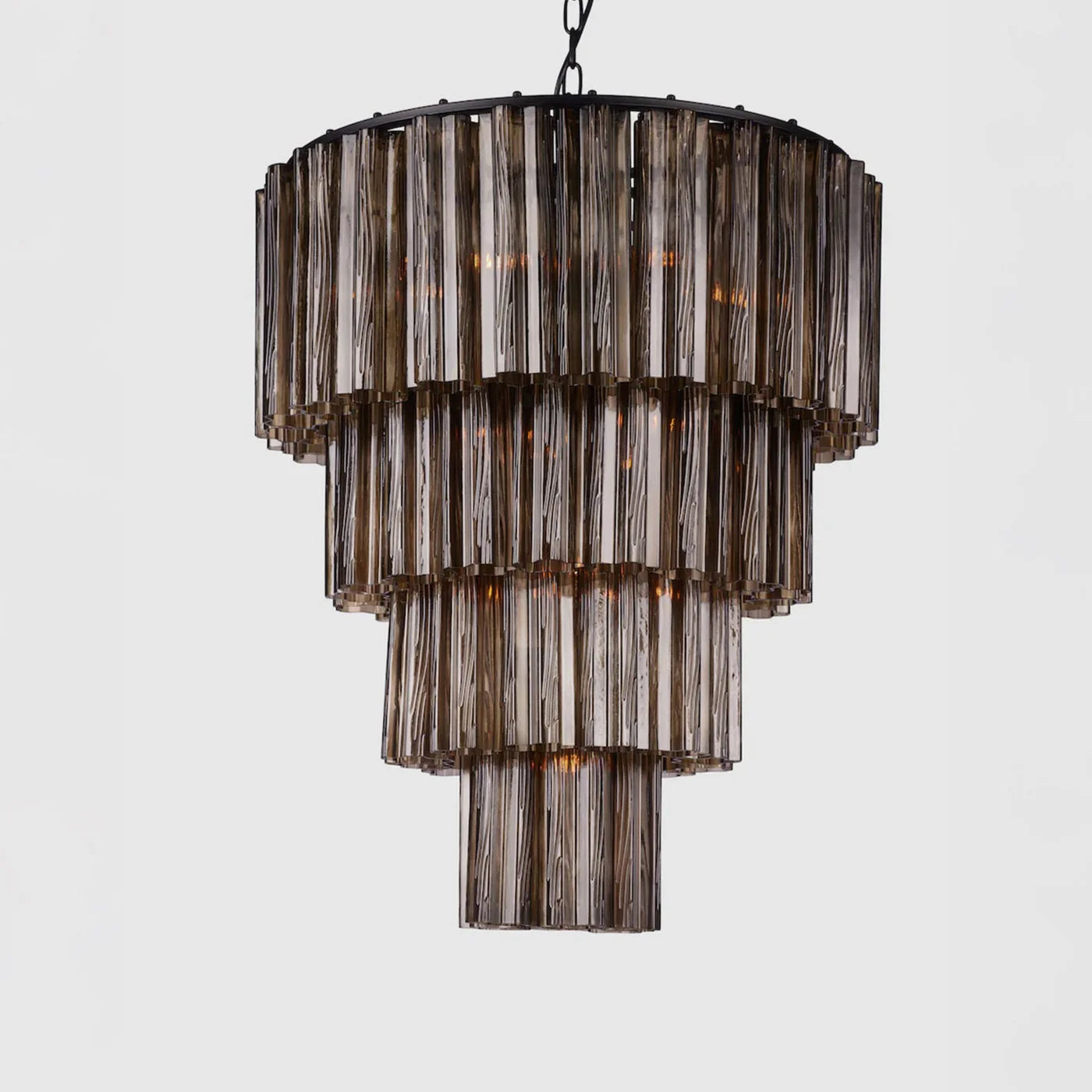Lysekronen Fontaine Chandelier fra norske Meublé i munnblåst brunt glass med svart oppheng. Her i den mellomste størrelsen, med 4 lag. 