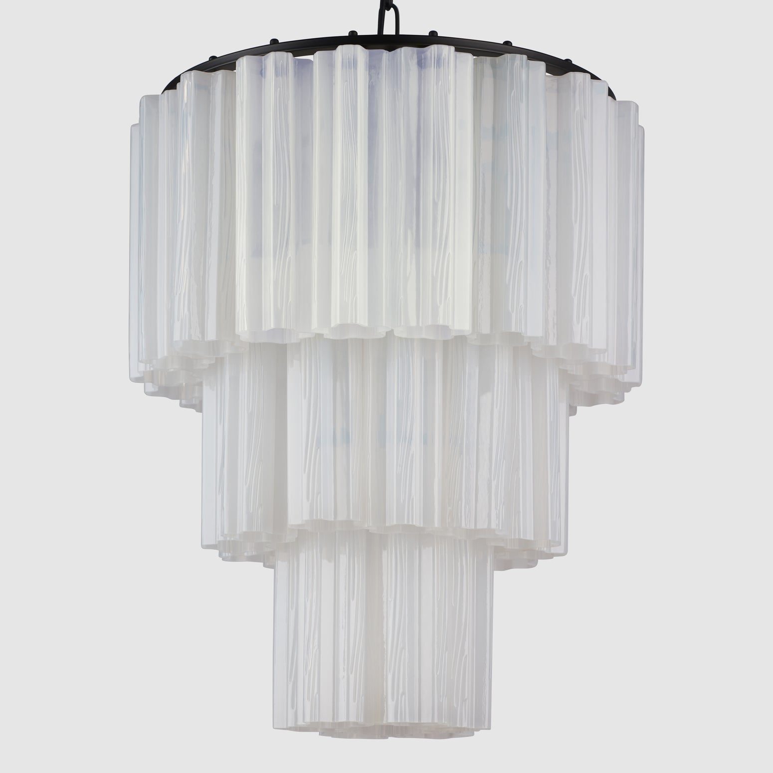 Lysekronen Fontaine Chandelier 3-layer fra norske Meublé smykker ethvert rom den henger i! Vi er spesielt begeistret for den med svart base og melkehvitt glass der de vakkert formede glassylinderne slipper lyset gjennom på en myk og delikat måte. Denne er perfekt for deg som er ute etter en moderne lysekrone som henger nydelig i en rosett, i stuen eller over et spisebord, i en større hall eller i et trappeløp – eller på soverommet! Her i hvitt glass med svart oppheng.