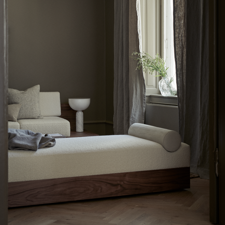 Her er dagsengen Mass Daybed kledd i tekstilet Karakorum i fargen Ivory 001, mens den runde puten er trukket i semsket skinn, i Sørensen Royal Nubuck Offwhite.