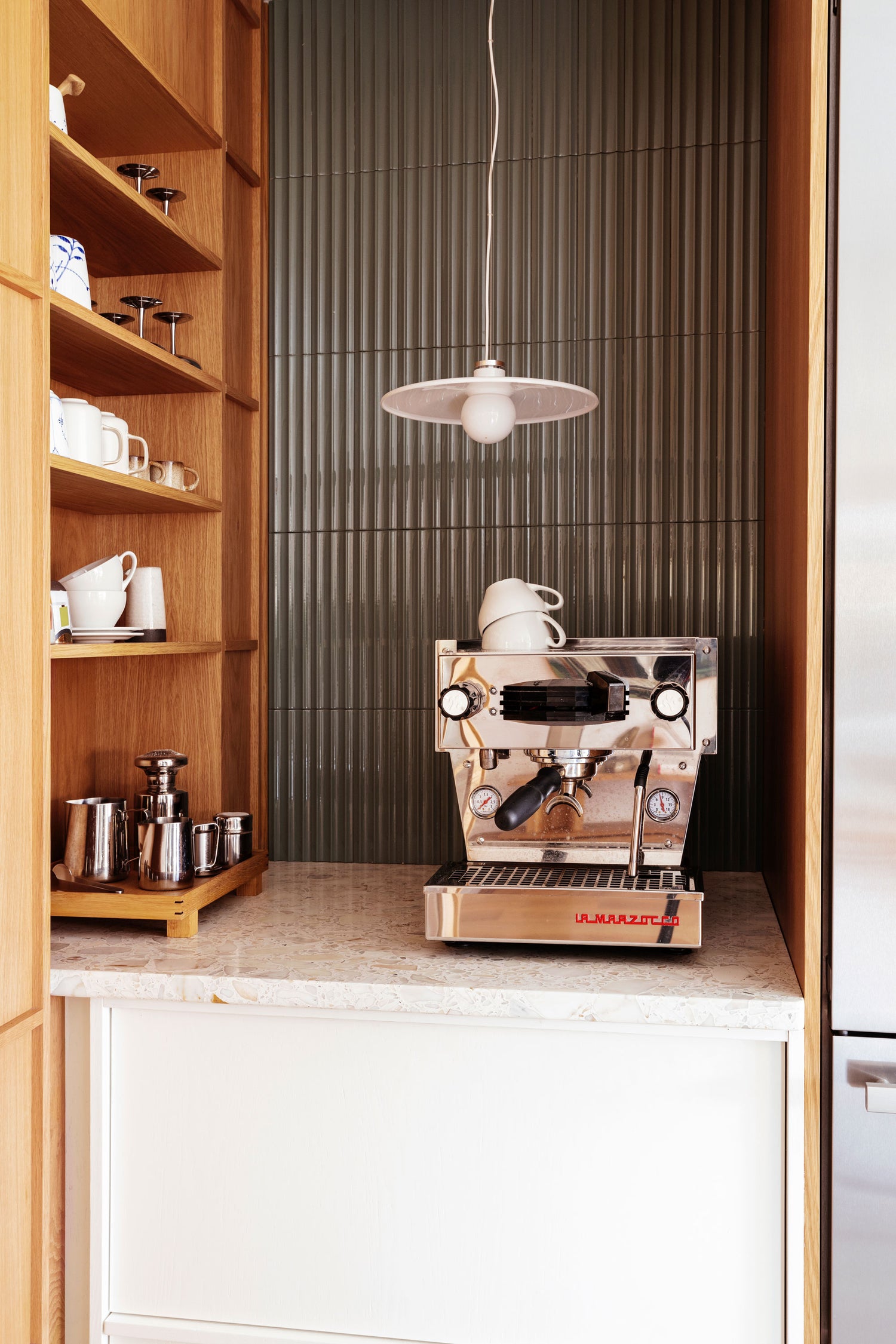 På kjøkkenet finnes det en egen kaffekrok med en kaffemaskin i blankt stål fra La Marzocco. Dette gir familien en følelse av hverdagsluksus.