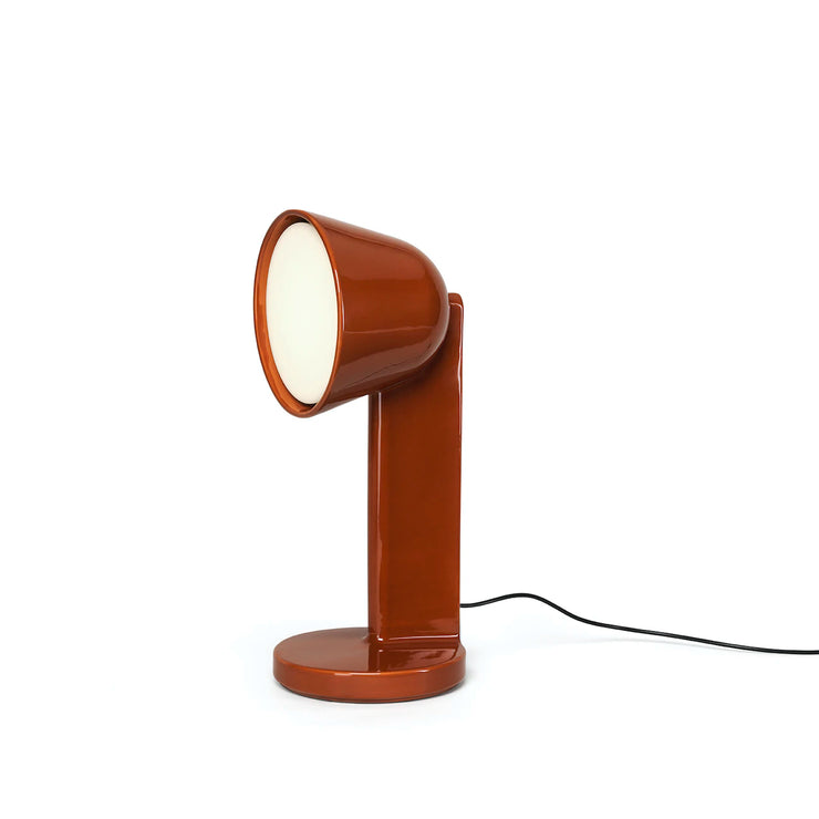 Bordlampen Céramique Side i fargen Rust Red. Denne projiserer lyset vinkelrett og er designet for å lyse opp en vegg eller et hjørne.
