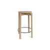 Barkrakk Passage Counter Stool fra Audo Copenhagen i eik med svart fotstøtte.